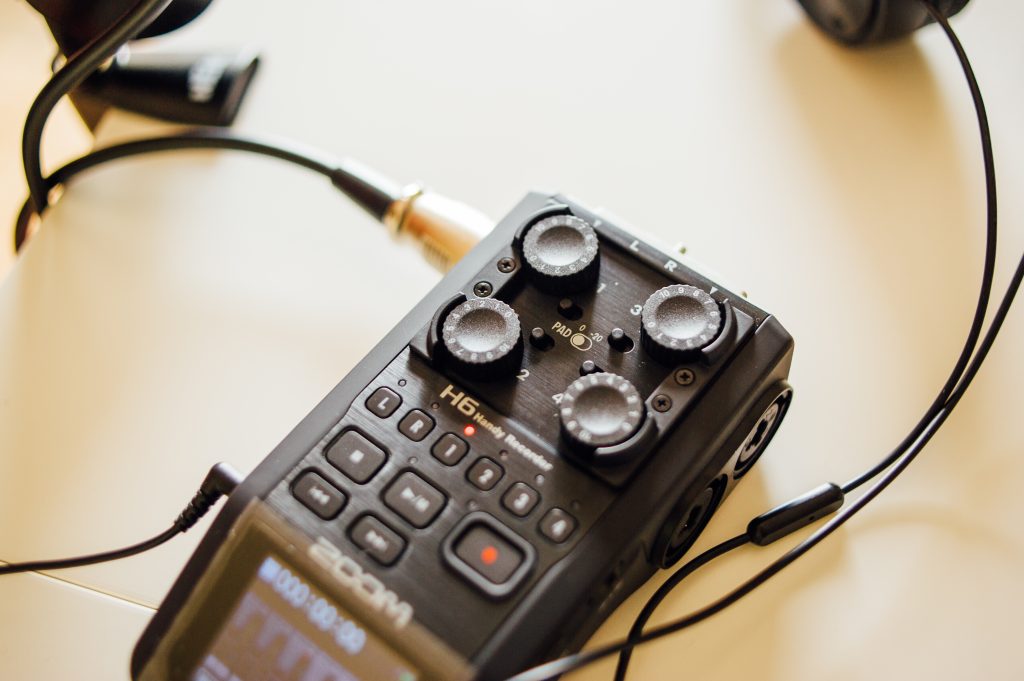 Picture of a Zoom H6 digital audio recorder with microphone plugged in