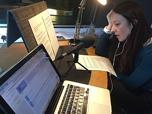 Sharon of Brand Content looking at a podcast script with a microphone in front of her